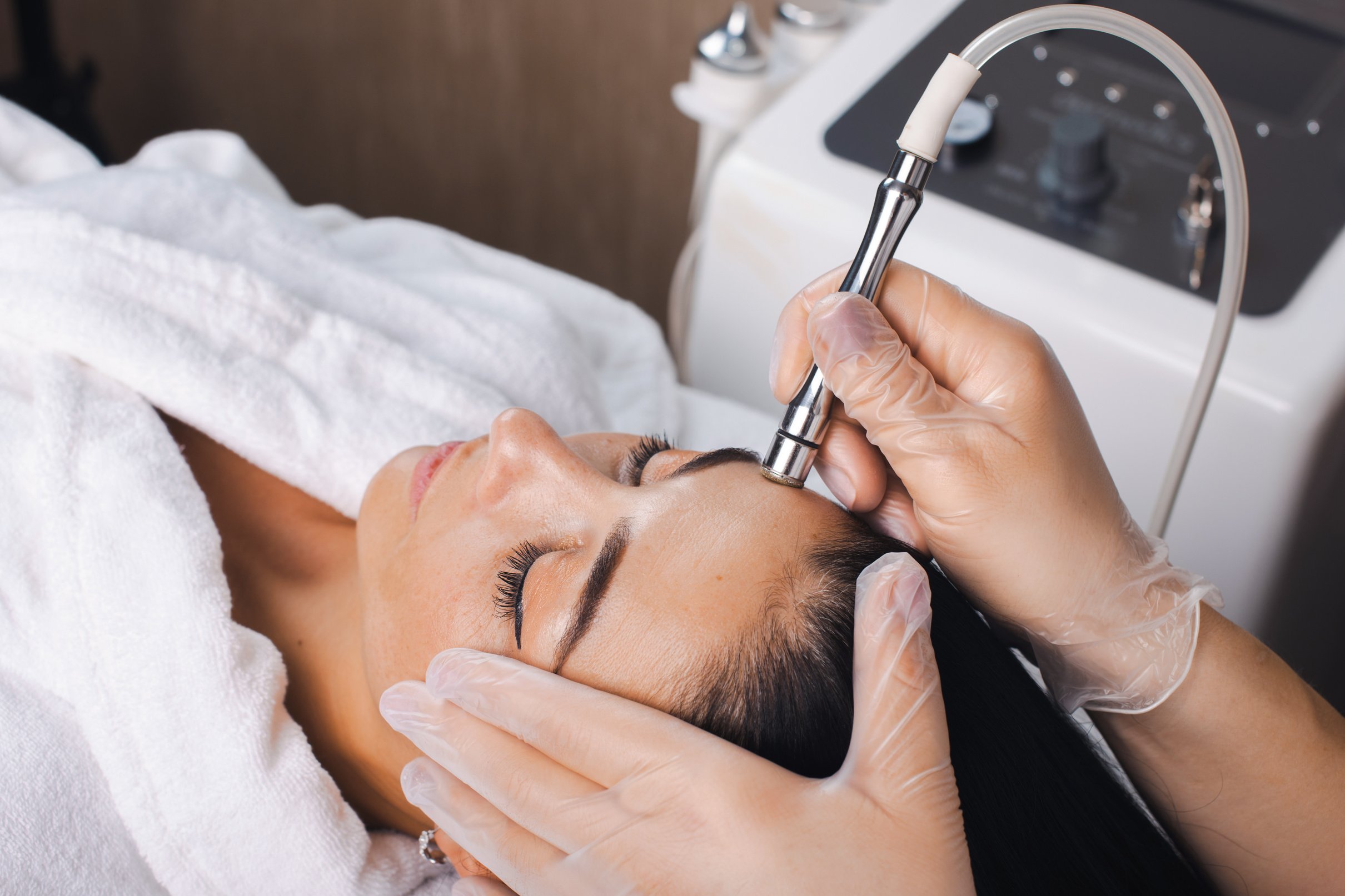 Cosmetologist's hand is making cavitation rejuvenation skin treatment. Facial treatment. Facial skincare. Beauty skin care. Rejuvenation treatment.